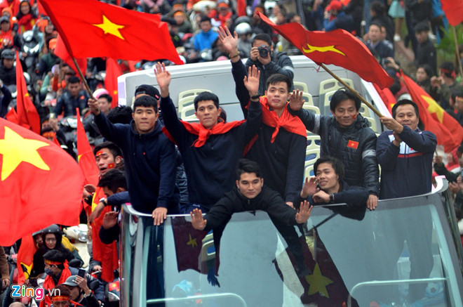 越南男足亚锦赛获亚军凯旋，民众举着*旗国**夹道欢迎