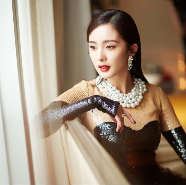 杨幂樱花树下秀性感身材，舔棒棒糖的姿势亮了