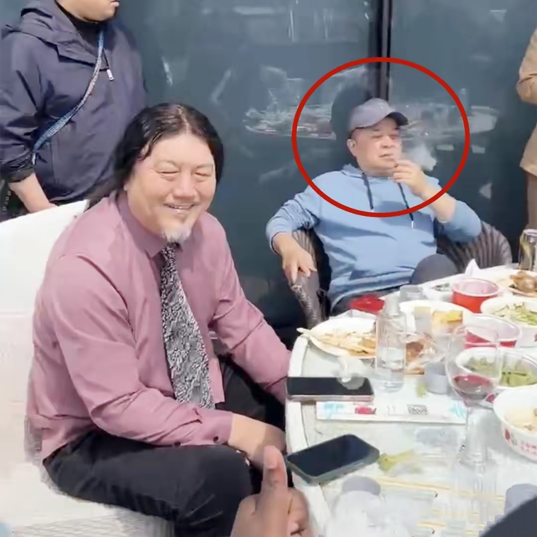 64岁毕福剑现身聚会，翘二郎腿抽烟姿势熟练，与网红合影被挤一旁